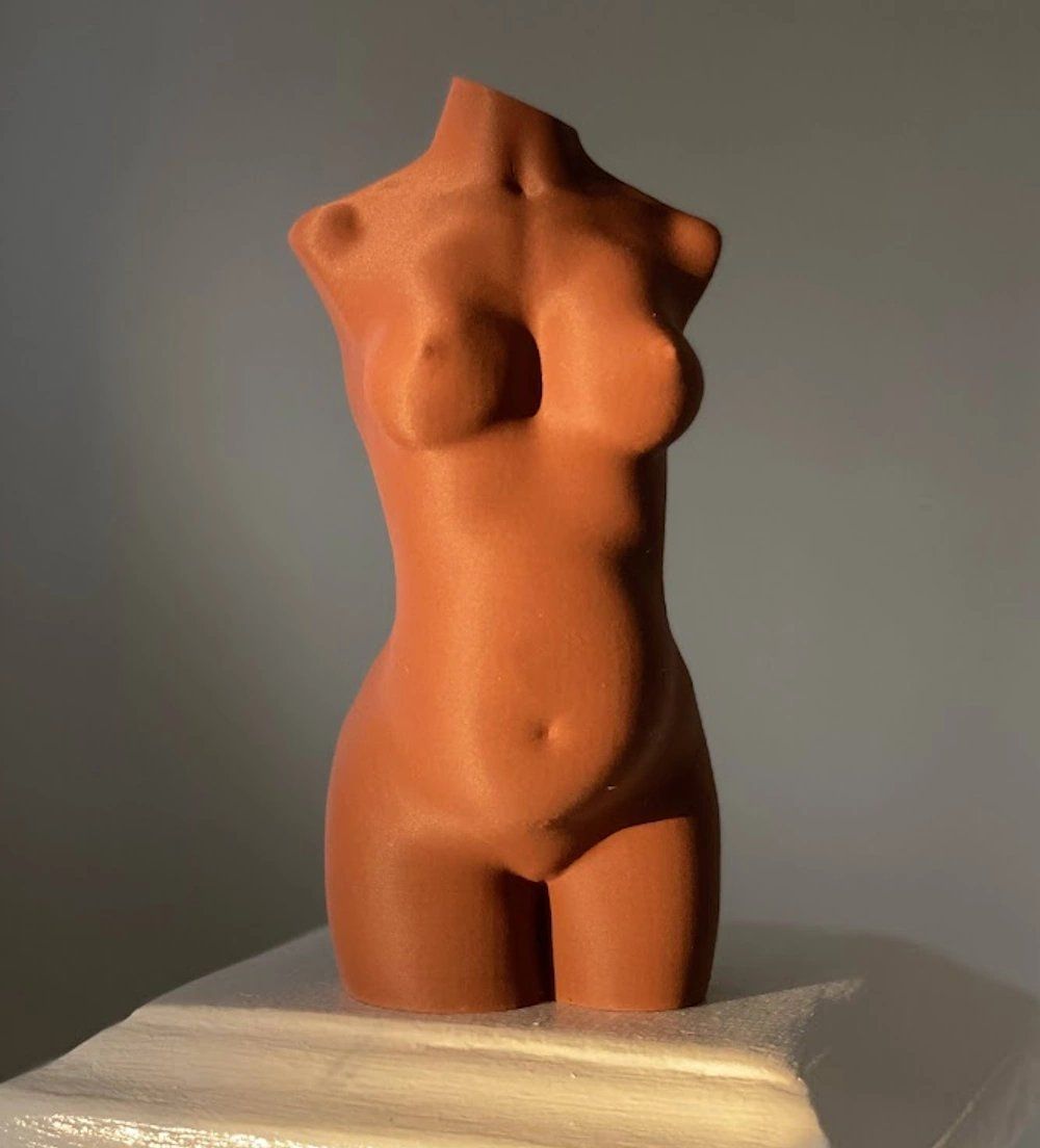 Copper Elysian pregnancy sculpture on a white plinth